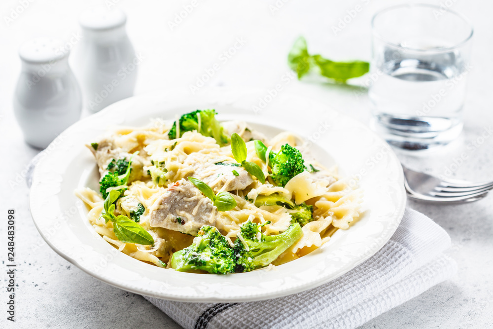 Italian pasta farfalle with broccoli, chicken and cheese in a white plate. Italian pasta farfalle with broccoli, chicken and cheese in a white plate.