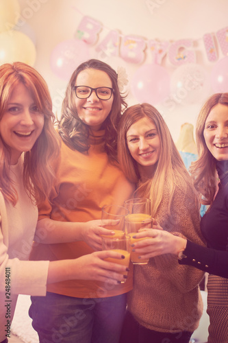 Pregnant woman celebrating baby shower party with friends.