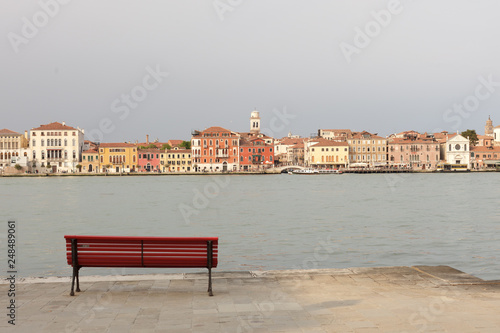 A red bench in the Giudecca island, watching the Canal Grande of Venice