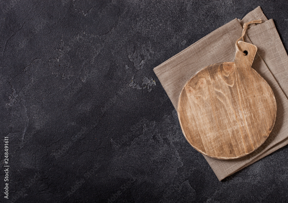 Vintage wooden cutting board on top of black stone kitchen stone