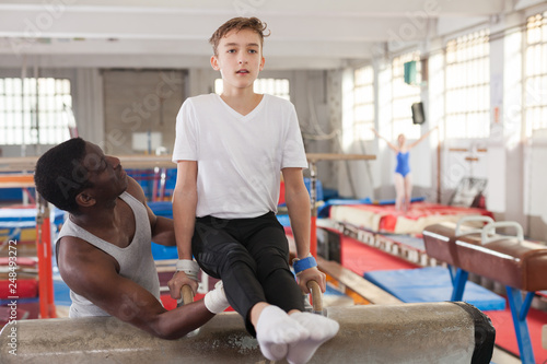 Afro trainer helping teenage athlete