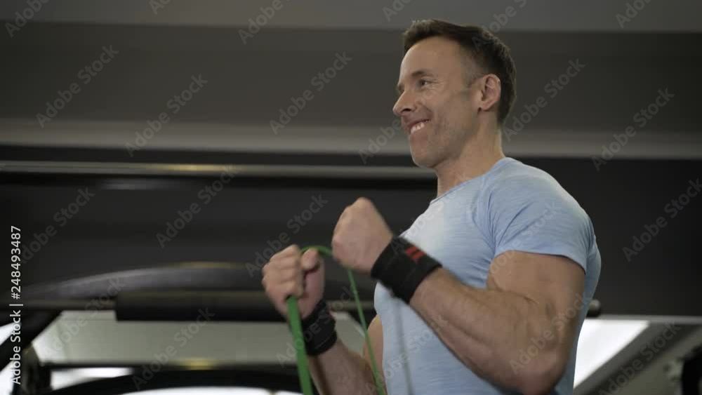Close up image of man doing exercise with elastic band at the gym. Close up image of man doing exercise with elastic band at the gym.