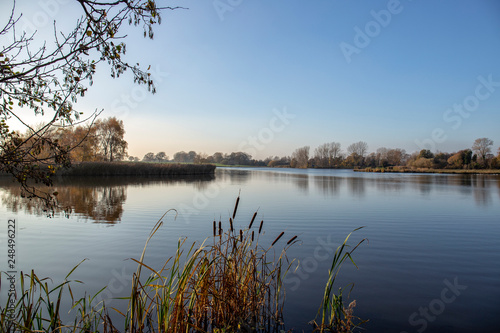 Early morning at a lake with blue sky in Cheshire England UK