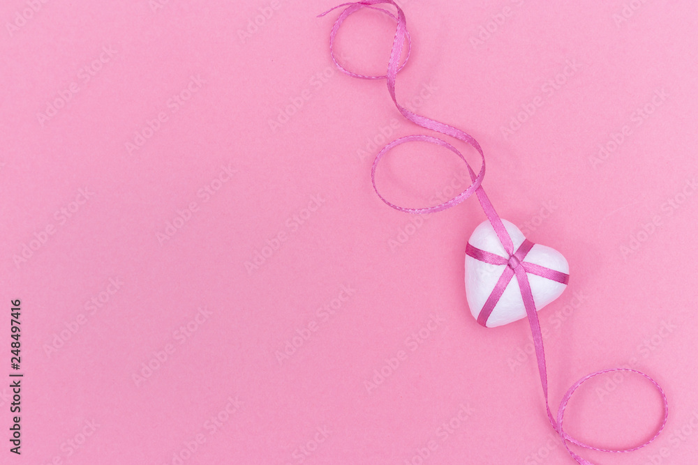 Love concept. White Heart and pink ribbon on pink paper background. Love concept. White Heart and pink ribbon on pink paper background.