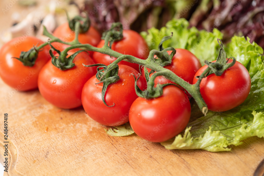 Branch of cherry tomatoes on wooden table closeup Branch of cherry tomatoes on wooden table closeup