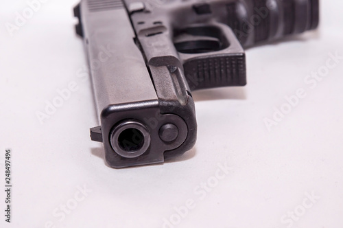 A black 9mm pistol laying on it's side on a white background