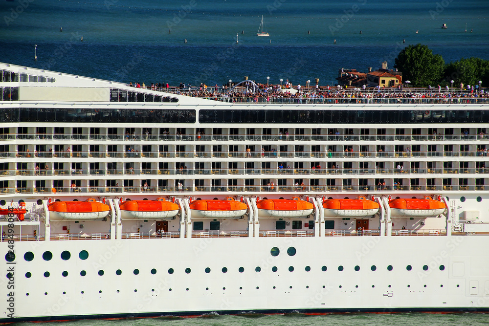 Detail of a crouded cruise ship moving through San Marco canal in Venice, Italy Detail of a crouded cruise ship moving through San Marco canal in Venice, Italy