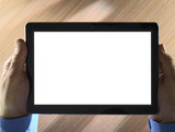 Holding tablet with white space for graphics or text on wooden background