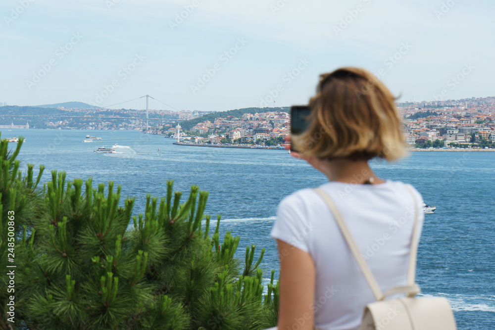 Traveler smartphone, landscape photography. Attractive girl takes a story on her smartphone while traveling Istanbul, Turkey. 