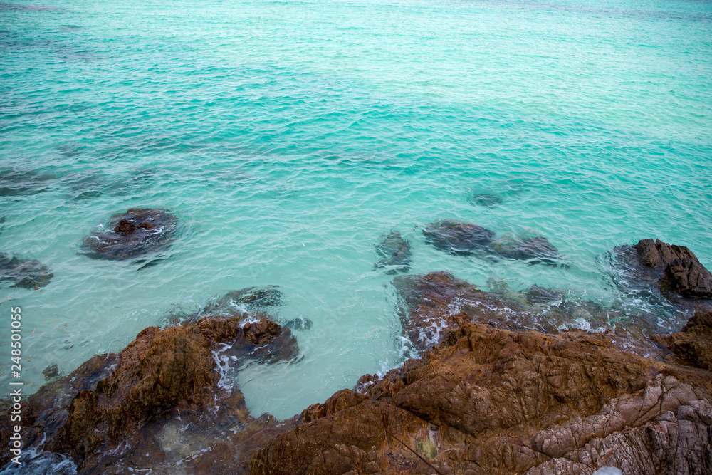 Obraz premium tropical beach rock and Soft wave of blue sea in summer