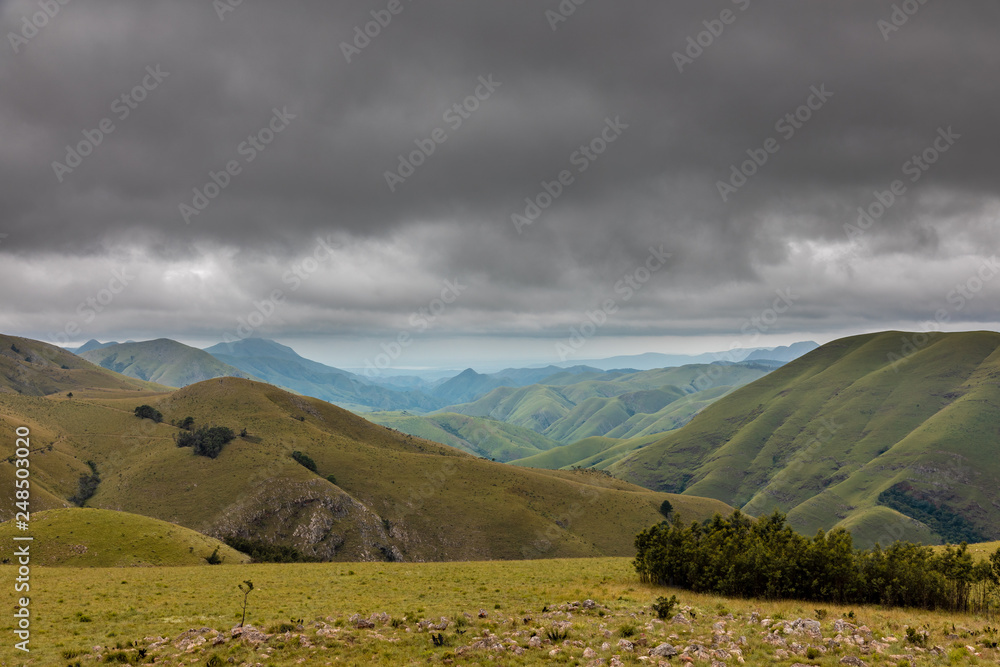 Grüne Hügel im Hochland von Südafrika mit bedrohlichen Wolken
