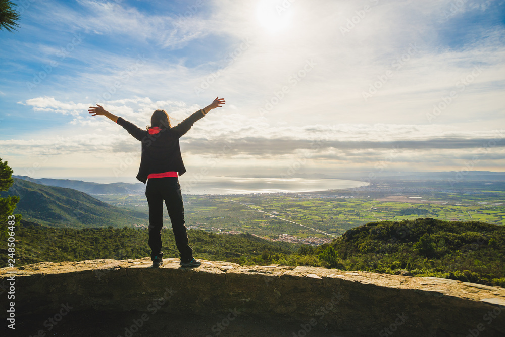 Girl raising hands, admiring a scenic view, freedom feeling Girl raising hands, admiring a scenic view, freedom feeling