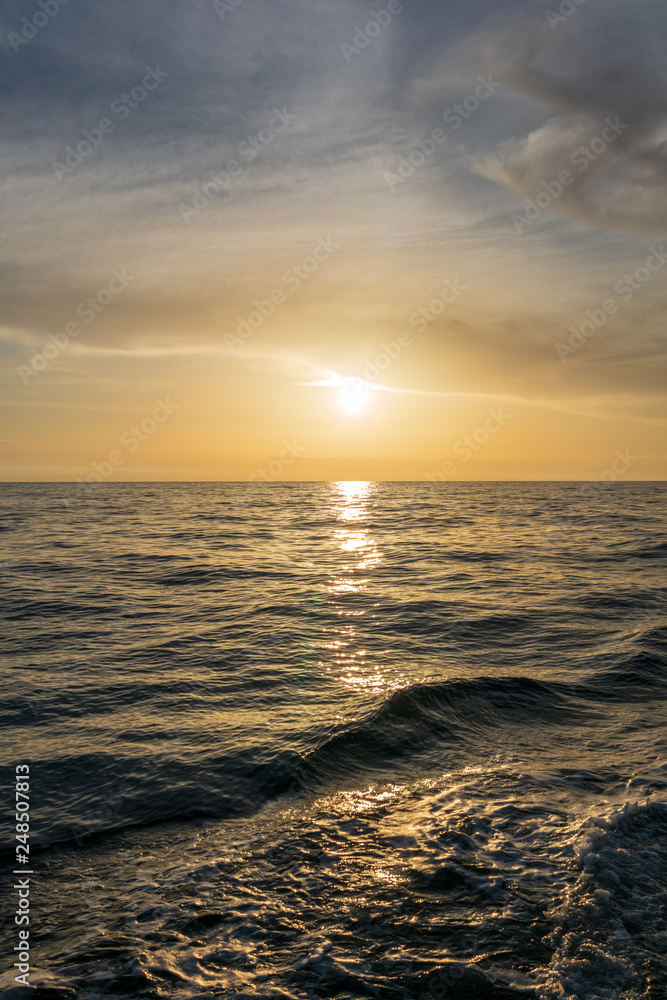 Waves astern of the yacht during orange sunset