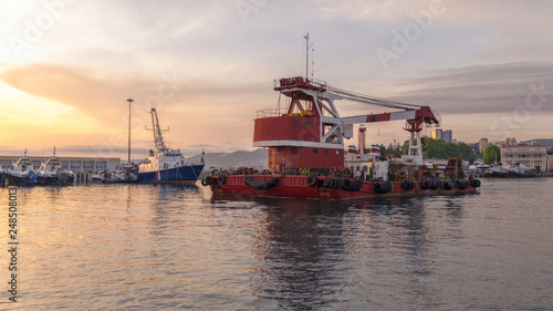 Large barge with a powerful crane in the port