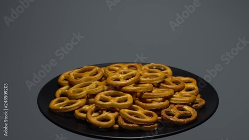 Pretzel salted in rotation. Close up. Studio shot. Grey background.  Unhealthy diet concept. Junk food concept.