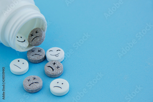 Pills medical. With painted faces and no pictures. Pills of joy, sadness,dead and indifference on blue background close-up