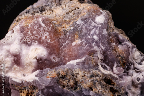 Macro pink Smithsonite mineral stone on microcline on black background