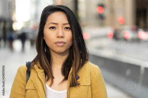 Young Asian woman in city serious face portrait