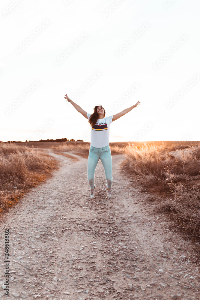 young woman jumping at sunset in the field young woman jumping at sunset in the field