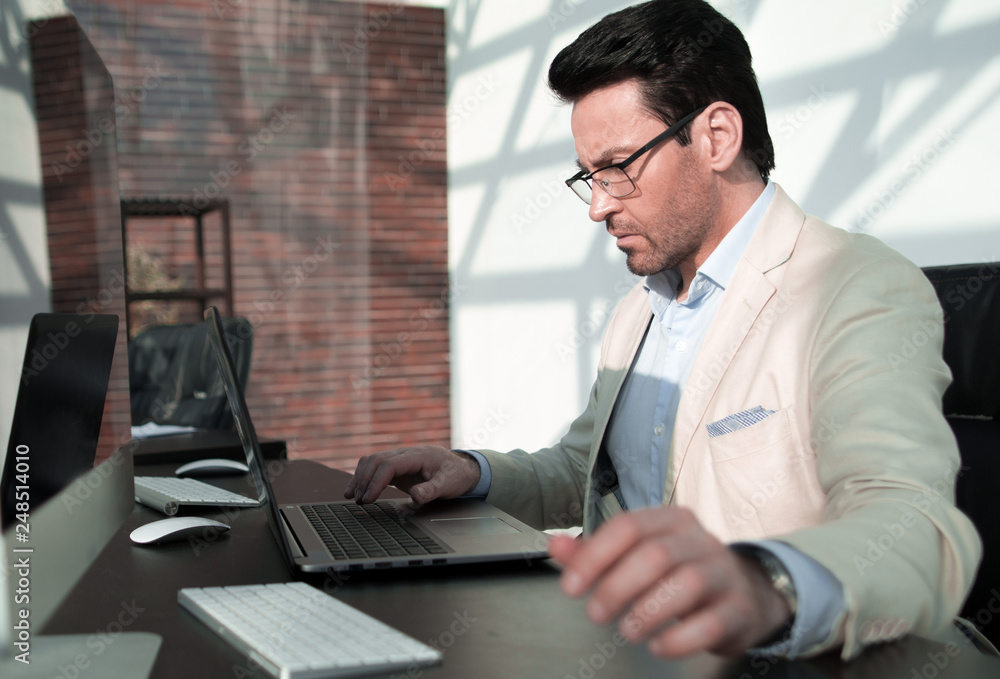 Fototapeta premium behind the glass.serious businessman with calculator sitting at his Desk