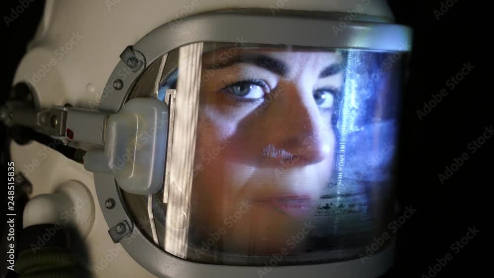 Close up shot of astronaut woman with the helmet visor up relaxing and breathing deep