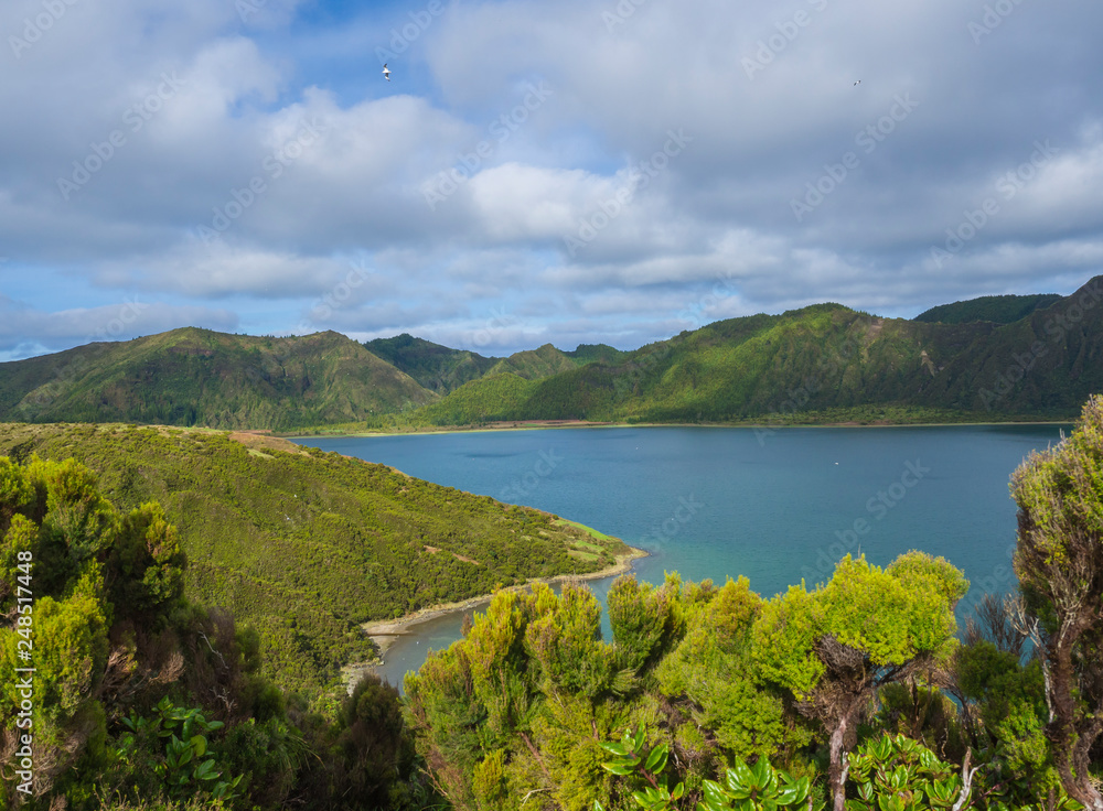 Landscape with beautiful blue crater lake Lagoa do Fogo from viewpoint Miradouro da Lagoa do Fogo. Lake of Fire is the highest lake of Sao Miguel island, surrounded by Natural Reserve green forest
