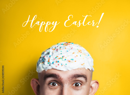 Funny Happy Easter concept. Emotional portrait of surprised bald man with easter cake on his head. half-face. Copyspace for text.