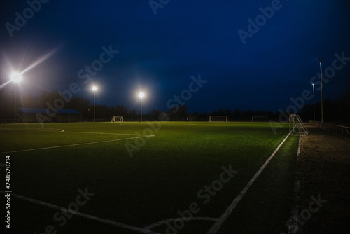 Football field at night illuminated by spotlights