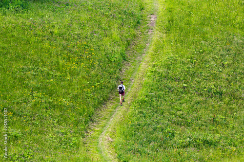 Mann läuft auf einem einsamen Weg in den Alpen