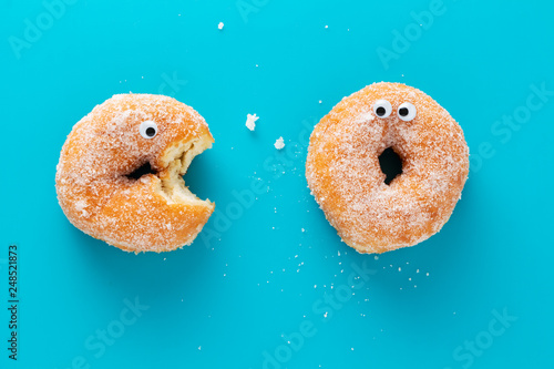 Valokuvatapetti Funny doughnuts with eyes, cartoon like characters, on blue background