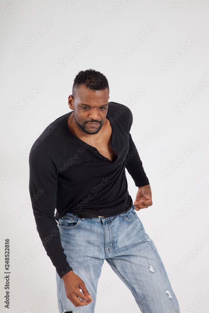 Thoughtful Black man in a black shirt and jeans Thoughtful Black man in a black shirt and jeans