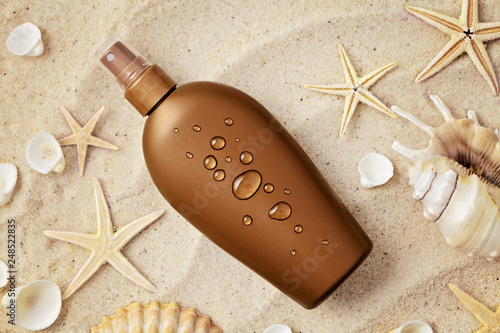 Foto suntan lotion and seashells on the sand beach