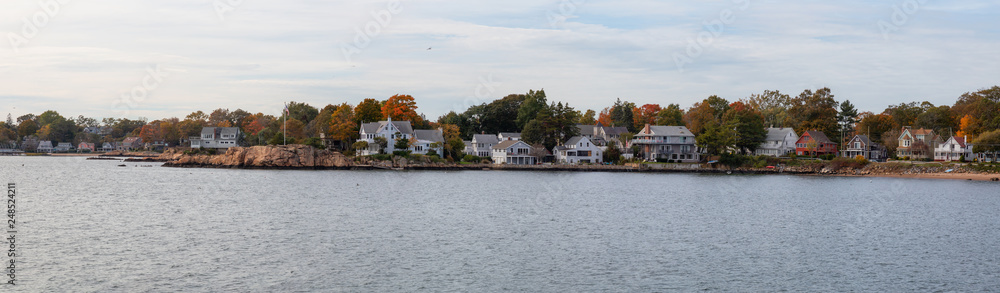Panoramic view on residential homes on the Rocky Coast during a cloudy day. Taken on the Atlantic Ocean in New Haven, Connecticut, United States.