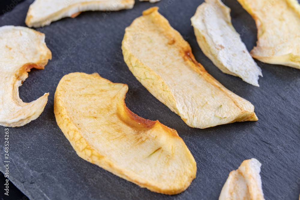 Tasty pieces of dried apples on the kitchen table. Delicious sweet additions to desserts. Tasty pieces of dried apples on the kitchen table. Delicious sweet additions to desserts.