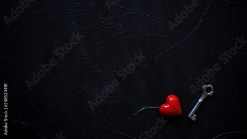 Red heart with vintage key on black background.Copy space.Valentines Day concept.Top view