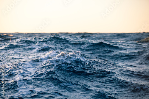 Large sea waves at sunset close up in a strong wind