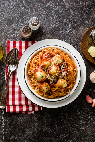 Italian pasta spaghetti with ricotta cheese balls in tomato sauce on the table with parmesan cheese. healthy traditional italian food for the whole family, party or restaurant menu