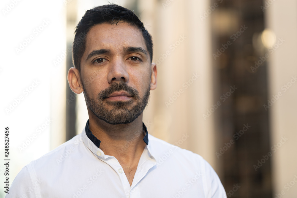 Young Latino Hispanic man in city serious face Young Latino Hispanic man in city serious face