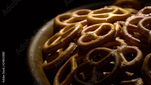 Pretzel salted in rotation. Close up. Studio shot. Black background. Unhealthy diet concept. Junk food concept.