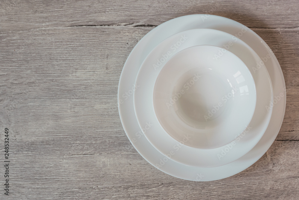 Empty white blank plate on wooden background with copy space. Top view. Empty white blank plate on wooden background with copy space. Top view.