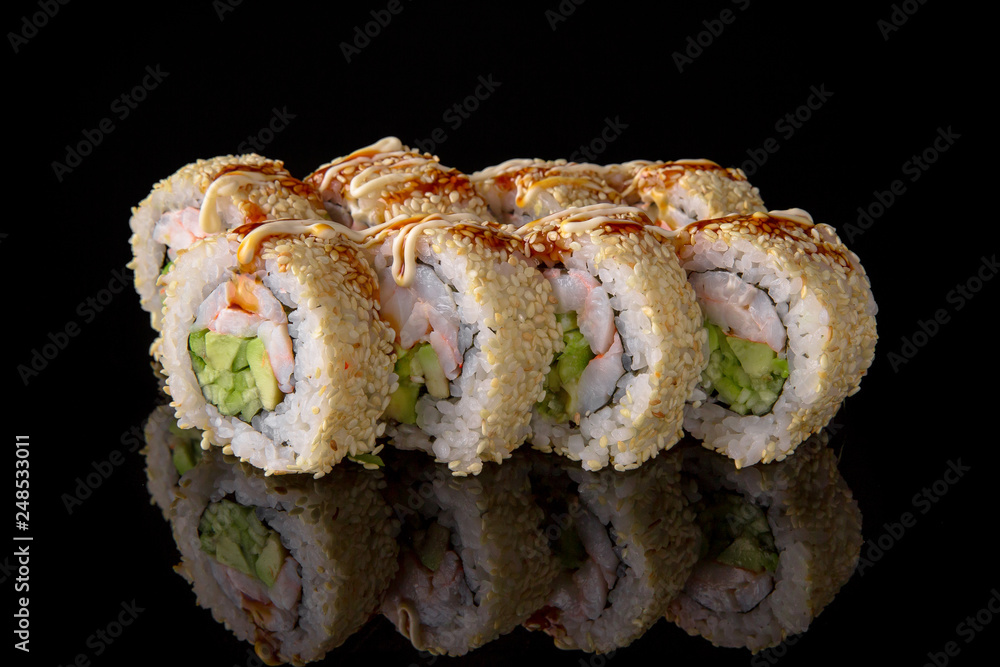 Sushi roll with shrimp, perch, avocado, unagi sauce on black background. Sushi menu. Japanese food. Sushi roll with shrimp, perch, avocado, unagi sauce on black background. Sushi menu. Japanese food.