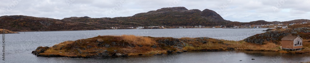 Small town on the Atlantic Ocean Coast during a cloudy morning. Goose Cove East, Saint Anthony, Newfoundland, Canada.