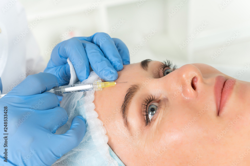 The doctor cosmetologist makes the Rejuvenating facial injections procedure for tightening and smoothing wrinkles on the face skin of a women in a beauty salon.Cosmetology skin care. The doctor cosmetologist makes the Rejuvenating facial injections procedure for tightening and smoothing wrinkles on the face skin of a women in a beauty salon.Cosmetology skin care.