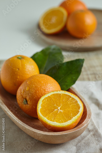 Oranges in a wooden bowl with leaves