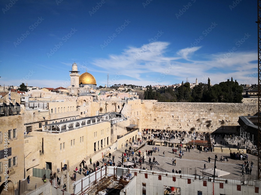 Fototapeta premium The Western Wall in Jerusalem, with many people visiting and praying at the most holy Jewish place. 