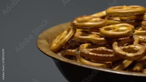 Pretzel salted in rotation. Close up. Studio shot. Grey background.  Unhealthy diet concept. Junk food concept.