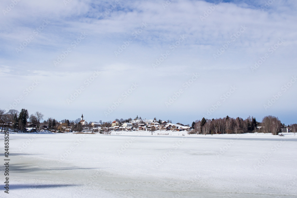 View in winter over the frozen lake Soier to the spa district in Bad Bayersoyen in Germany