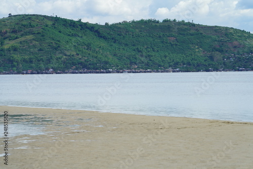 View of Manjuyod Sandbar, Philippines with a tropical green island background