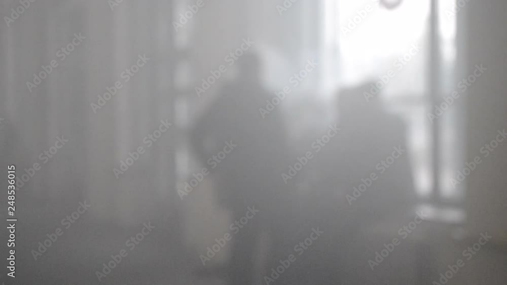 Many people walk in a smoke filled room Many people walk in a smoke filled room