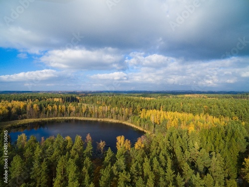 Aerial view of beautiful covered with forest landscape of Mazury region during autumn season, Ogonki, Poland